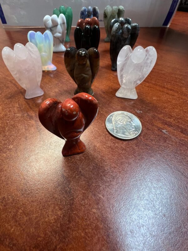 Carved stone angel figurines on wood table.