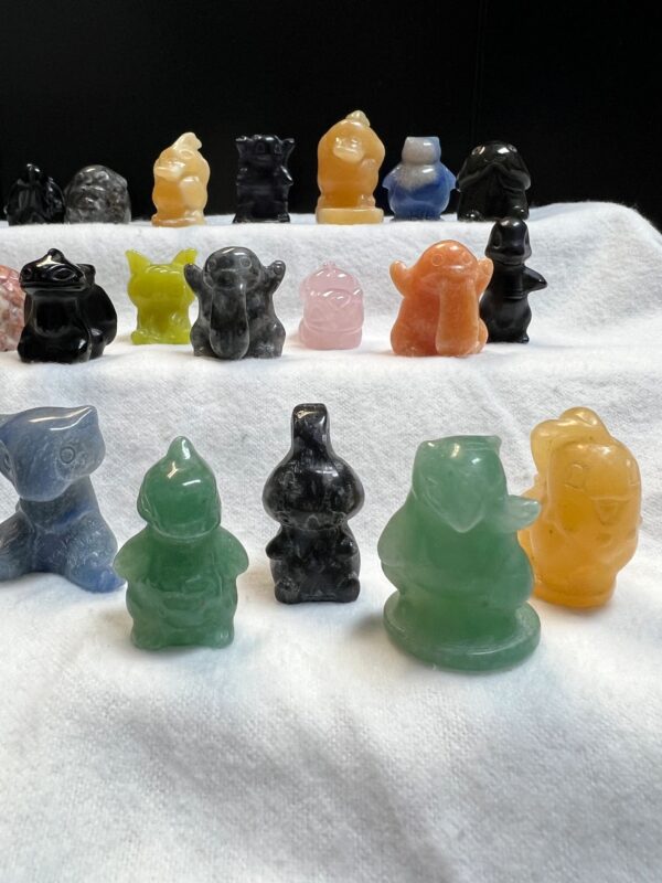 Colorful crystal figurines on white fabric.