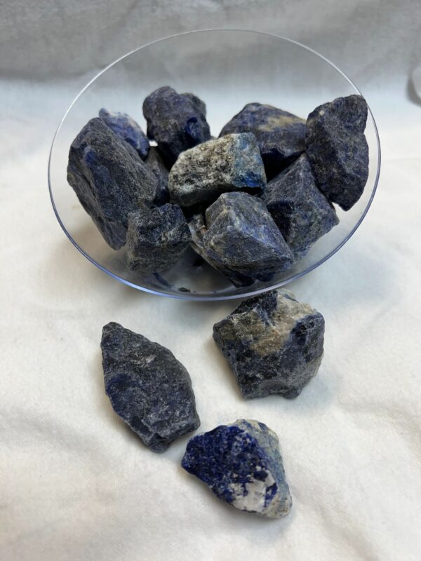 Rough blue lapis lazuli stones in bowl.