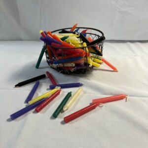 Multicolored candles in a wire basket.