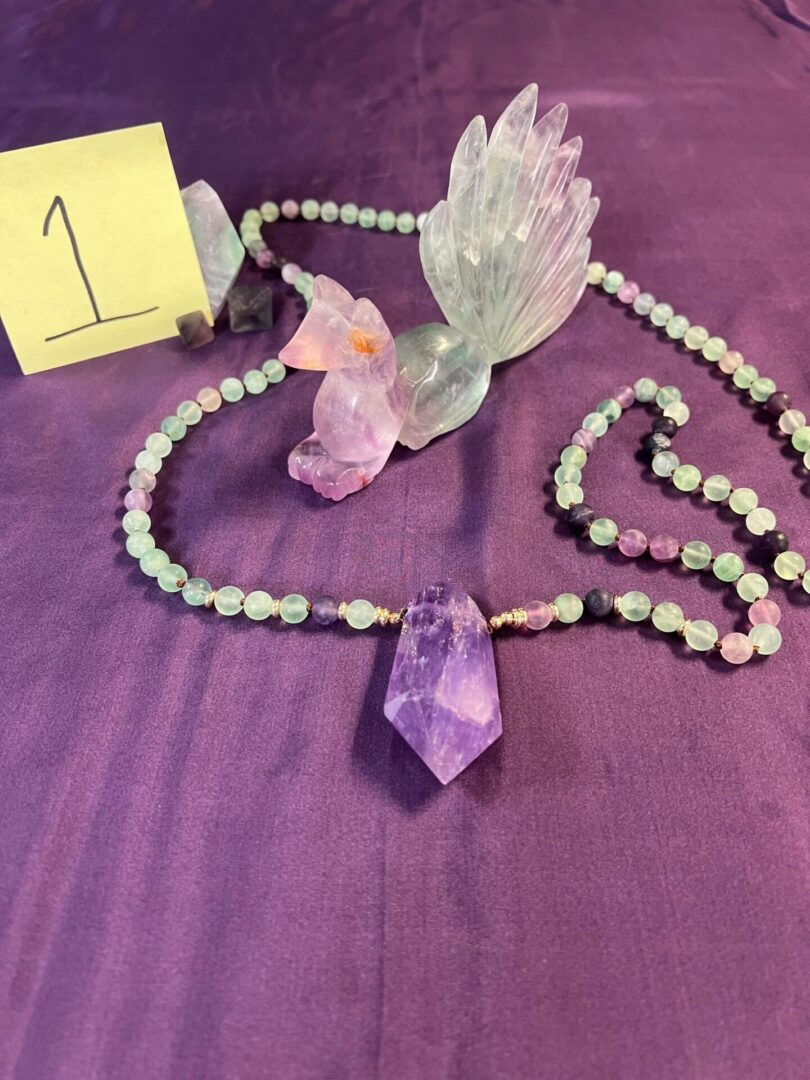 Green fluorite crystal necklace with amethyst pendant.