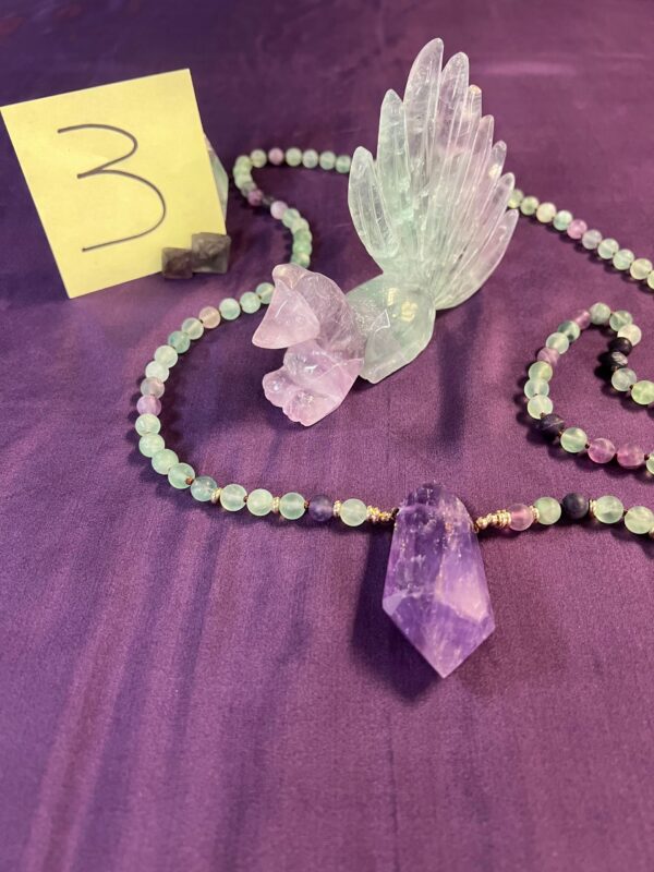 Amethyst crystal necklace with green beads.