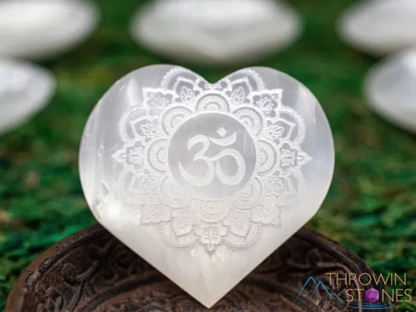 White selenite heart with om symbol.