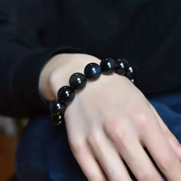 Black gemstone beaded bracelet on wrist.