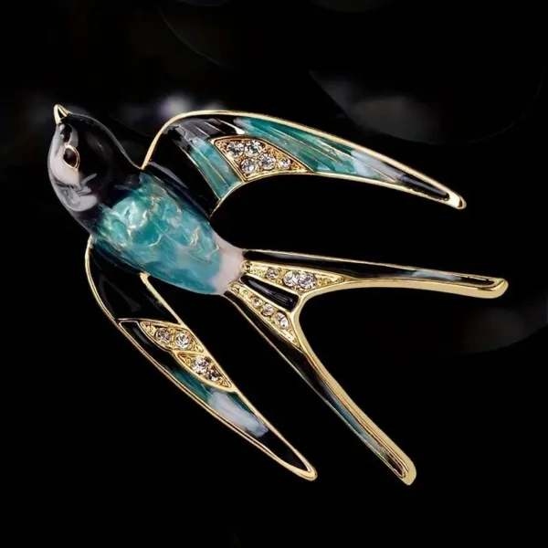 Gold swallow brooch with blue enamel and rhinestones.