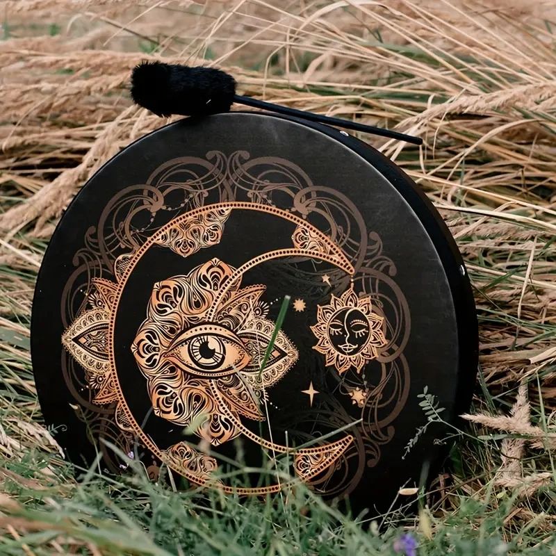 Black drum with moon and eye design.