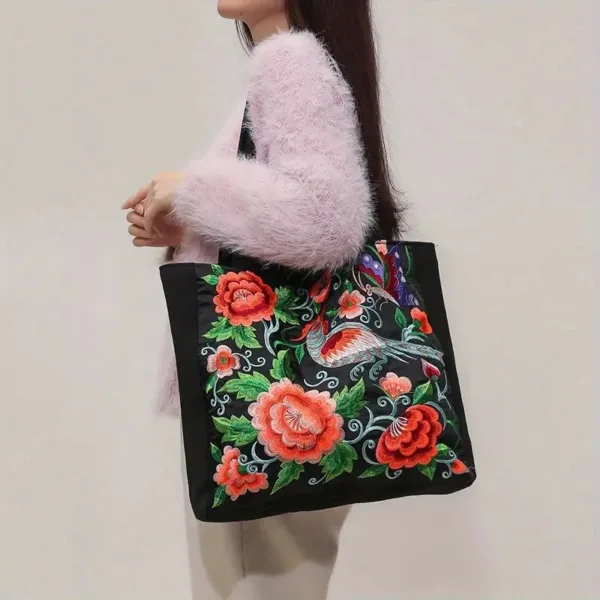 Woman holding embroidered floral tote bag.