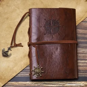 Brown leather journal with compass and anchor charms.