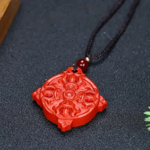 Red carved pendant on black cord necklace.