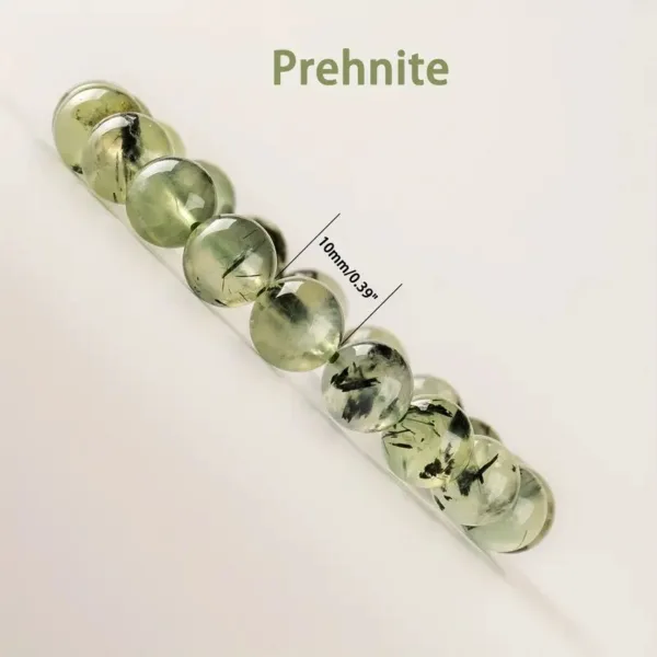 Prehnite gemstone bracelet with black inclusions.