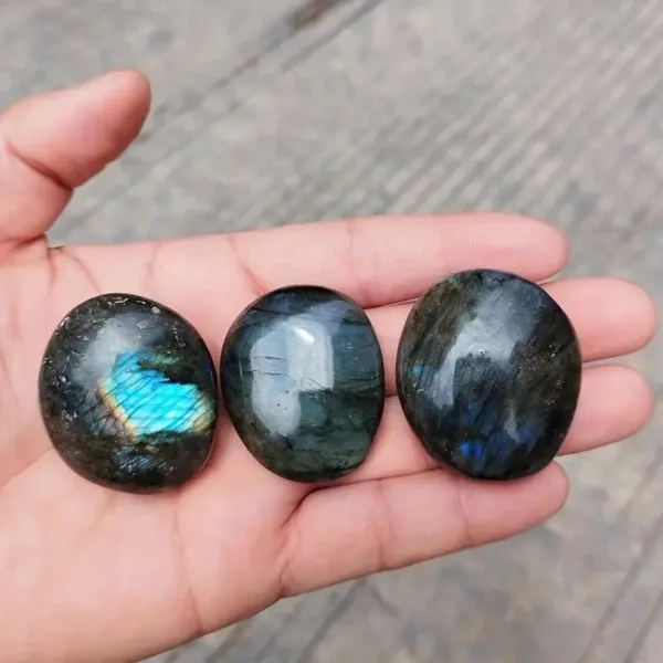 Three labradorite tumbled stones in hand.