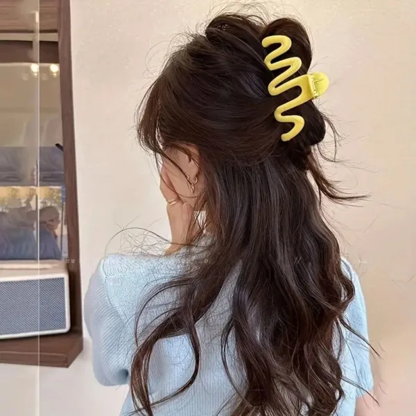 Woman with long hair wearing a yellow claw clip.