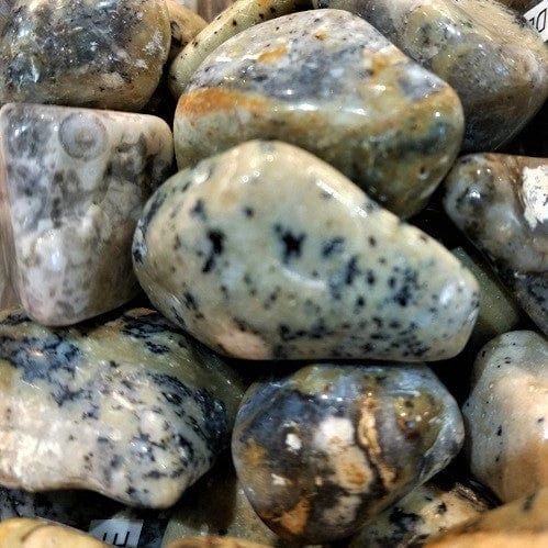 Close-up of smooth, grey, green, and brown stones.