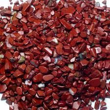 Red gemstone chips on a white background.