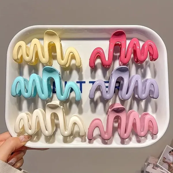 Colorful wavy hair clips in tray.