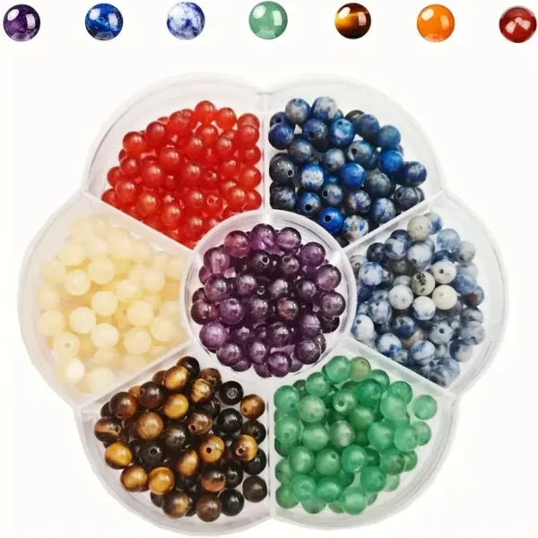 Seven colors of gemstone beads in a tray.