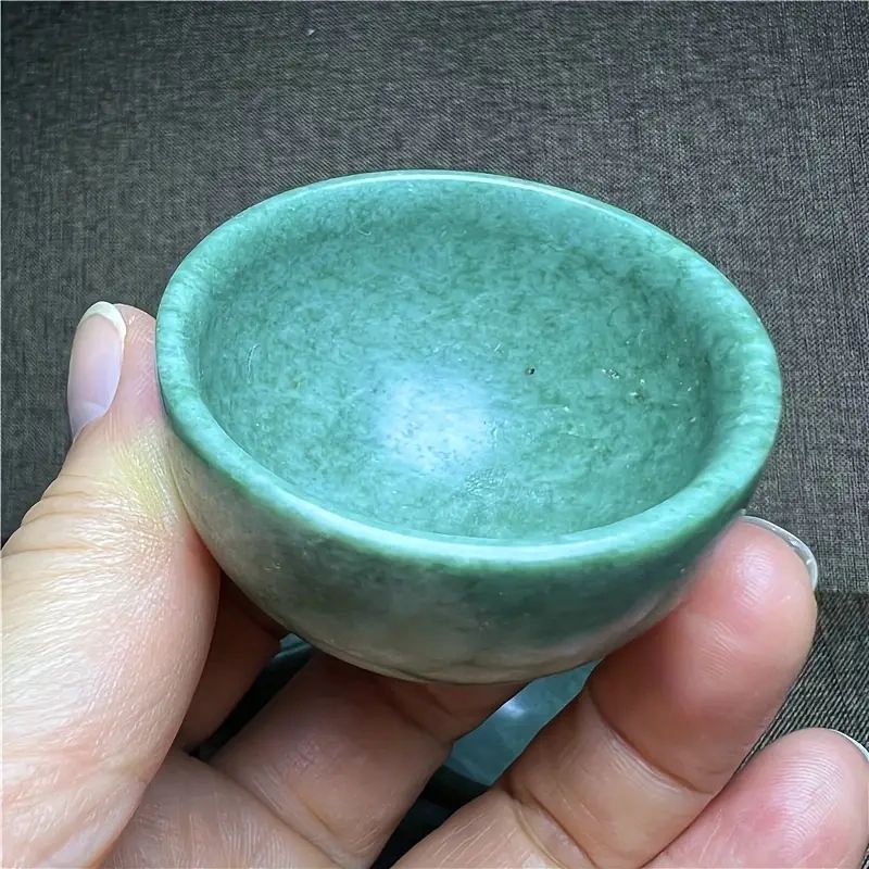 Green jade stone bowl in hand.