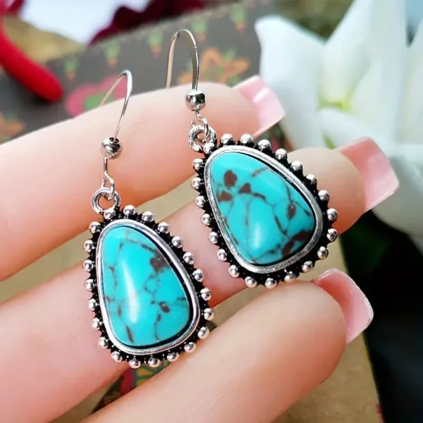 Silver teardrop earrings with turquoise stones.