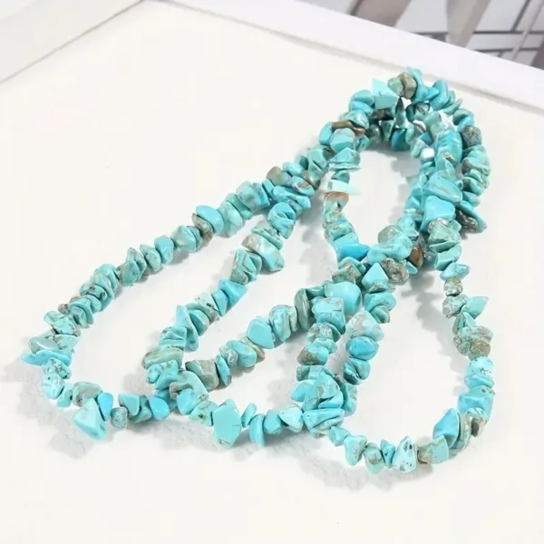 Turquoise chip bead necklace on white background.