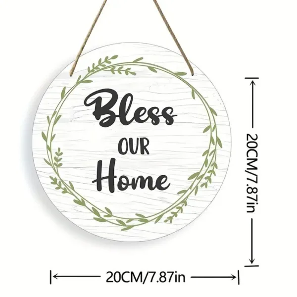 Round wooden sign with "Bless our home" and green leaves.