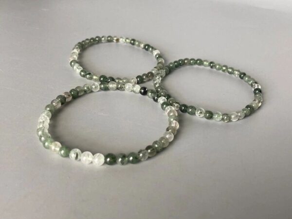 Three green and clear beaded bracelets.