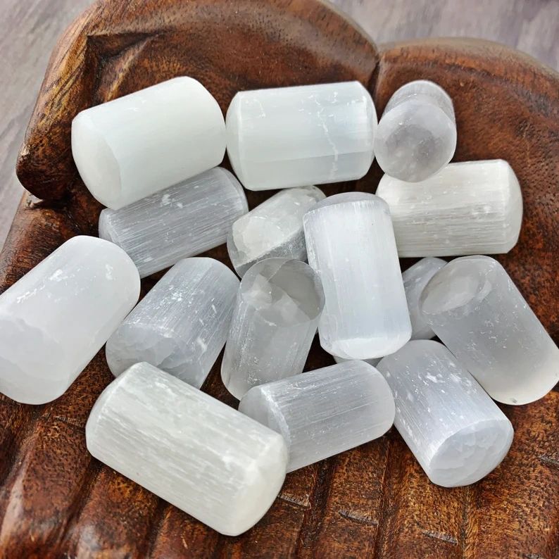 White selenite sticks on wooden surface.