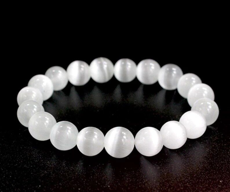 White gemstone beaded bracelet on black background.