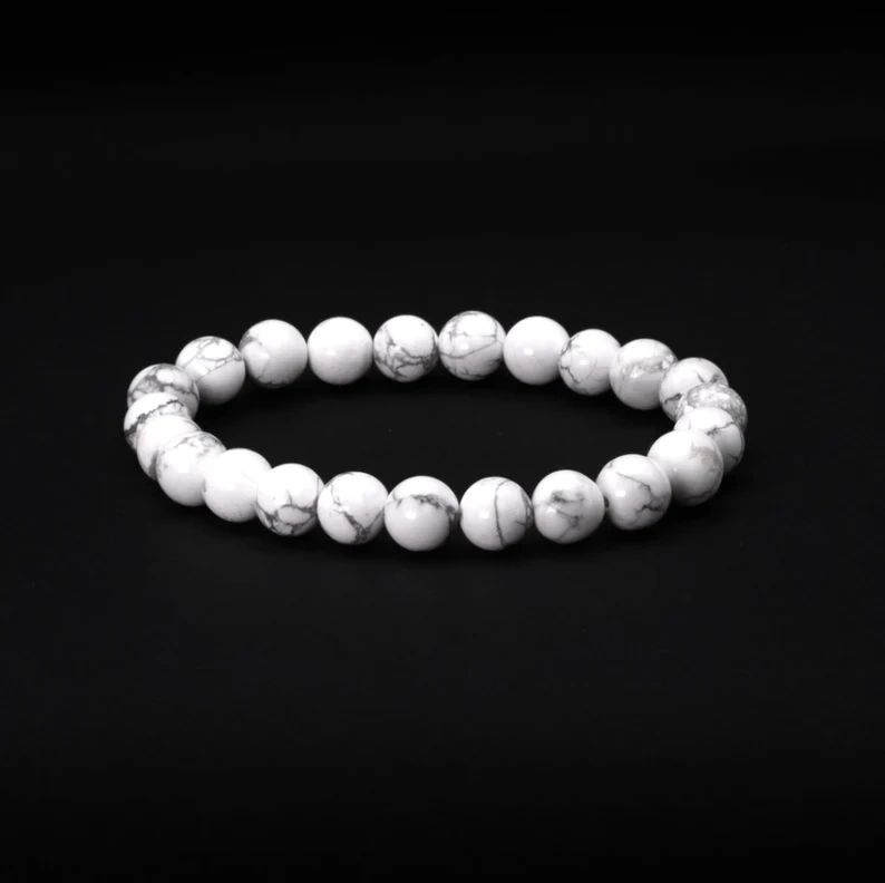 White howlite beaded bracelet on black background.