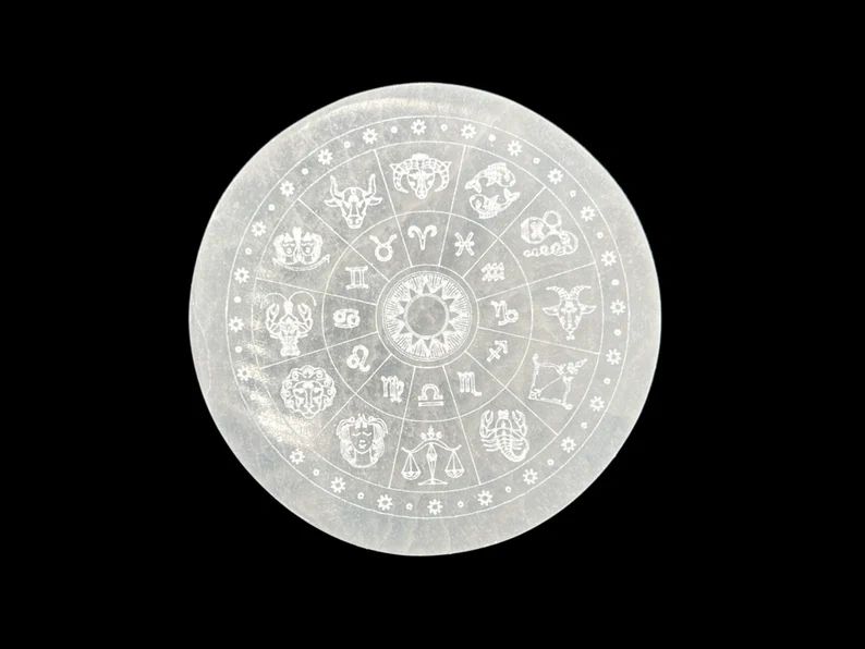 White selenite zodiac wheel with symbols.