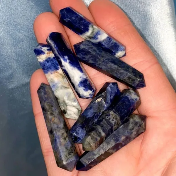 Hand holding blue and white gemstone wands.