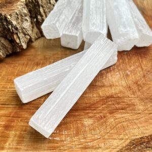 White selenite sticks on wood background.