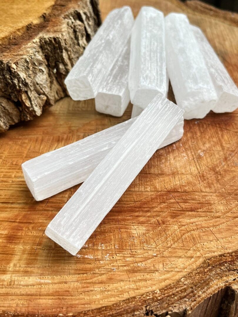 White selenite sticks on wood background.