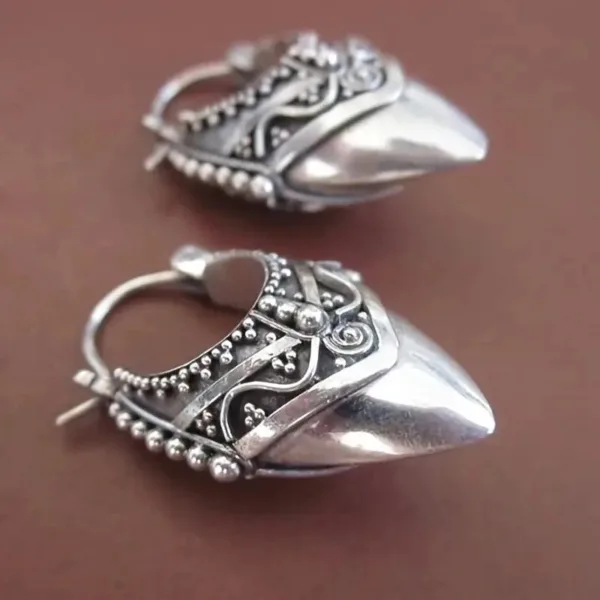 Silver ornate hoop earrings with points.