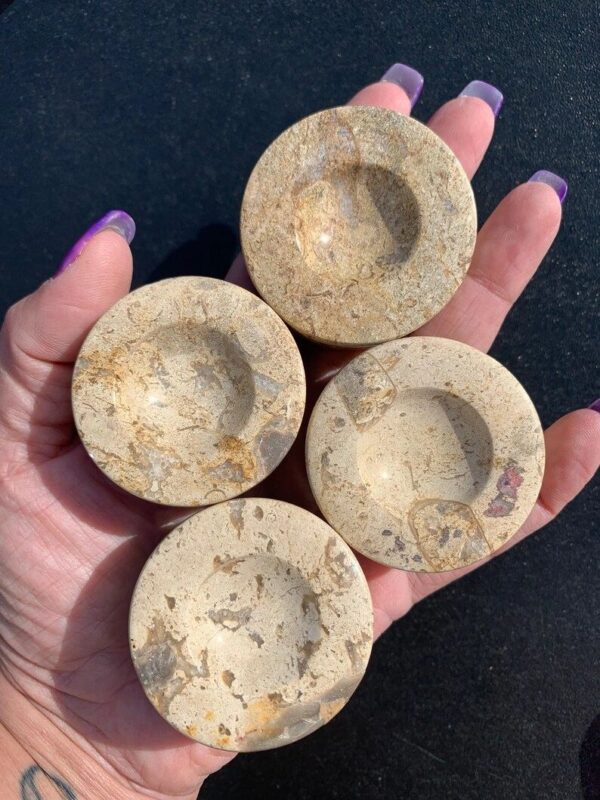 Four round beige stone coasters.