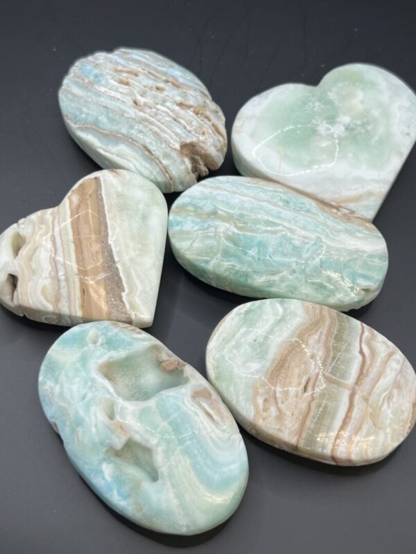 Polished green and brown gemstone hearts and ovals.