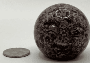 Gray and black speckled stone sphere.