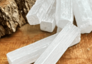 White selenite crystal sticks on wood.