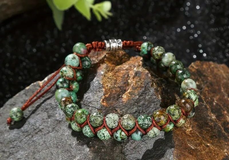 Green stone beaded bracelet on rock.